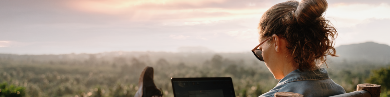 Vrouw met laptop op balkon